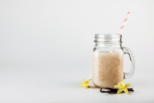 Protein cocktail with milk, vanilla in a glass jar with straws. Sports nutrition