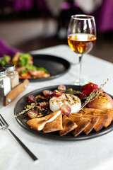Grilled camembert with baked apple and grapes with slices of bread cakes