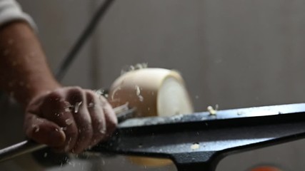 flying sawdust and shavings while woodturning of a wooden bowl.