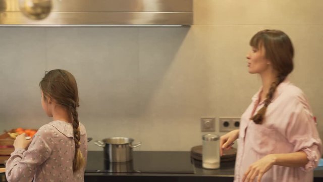 A mother gives a powdered sugar to her daughter and instructs hers every next step in order to teach her how to cook.