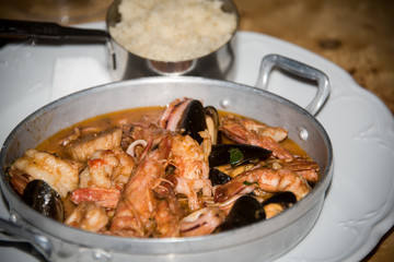 Seafood and sea fish in tomato sauce .