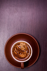 a cup of coffee and chocolate candies on a dark background.