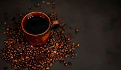 Naklejka premium Coffee cup with roasted beans on stone background