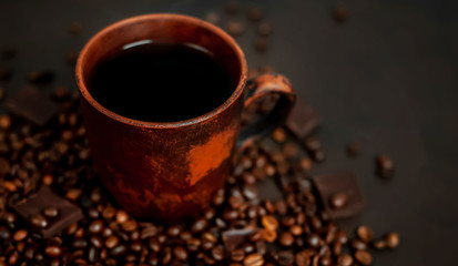 Coffee cup with roasted beans on stone background