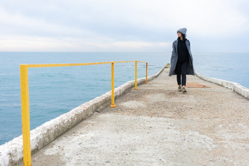Girl walking on the pier. Vacation, walk and tourism. Lifestyle.