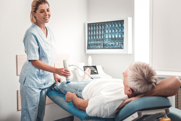 Blonde-haired chiropractor enjoying communicating with patient