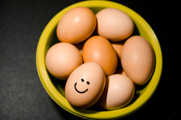 Egg with smiling face in the green basket
