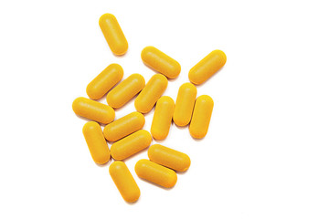 scattering of yellow vitamins on a white table