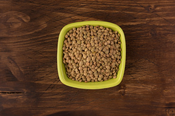 Yellow lentil in a bowl on wooden background