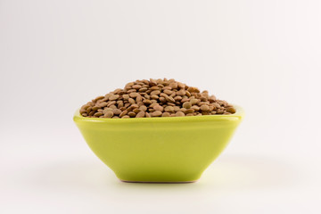 Yellow lentil in a bowl isolated on white background