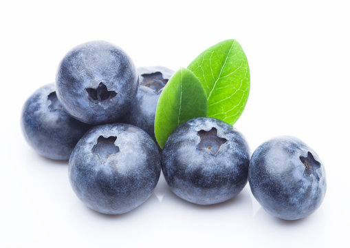 Fresh raw organic blueberries with leaf on white background. Macro close up