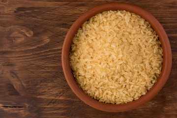 white rice in bowl on wooden table background