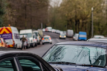 Defocused background with view to road with cars parked all around.