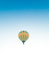 Fototapeta na wymiar Colorful hot air balloon isolated on blue sky background. Colorful hot air balloon flying over at fairy chimneys in Nevsehir, Goreme, Cappadocia Turkey. 