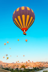 Fototapeta premium Colorful hot air balloons flying over at fairy chimneys in Nevsehir, Goreme, Cappadocia Turkey. Hot air balloon flight at spectacular Cappadocia Turkey. 