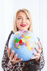 beautiful cheerful smiling blonde woman travel agent holding globe in her hands 