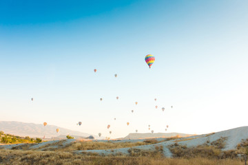 Colorful hot air balloons flying over at fairy chimneys in Nevsehir, Goreme, Cappadocia Turkey. Hot air balloon flight at spectacular Cappadocia Turkey.  
