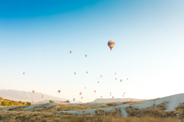 Colorful hot air balloons flying over at fairy chimneys in Nevsehir, Goreme, Cappadocia Turkey. Hot air balloon flight at spectacular Cappadocia Turkey.  