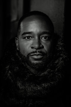 Close up lack and white photo of a black man in a dark atmosphere