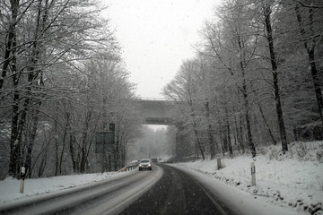 Autofahrt bei Schneefall und glatter Straße - Stockfoto