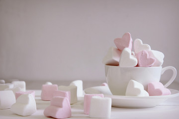 Sweet marshmallows in the shape of heart in the ceramic cup with pink background. Concept about love and relationship. Romantic Style, Creative for colorful greeting card. Valentines day background he