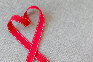 Heart made from red ribbon on linen textile with space for text, Valentine's Day concept.