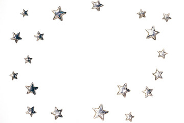 Beautiful shining silver stars with embossed transparent top arranged in circle on isolated white background. Copy space. Top view.