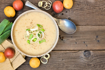 Potato and leek soup. Above view table scene on a rustic wood background with copy space.