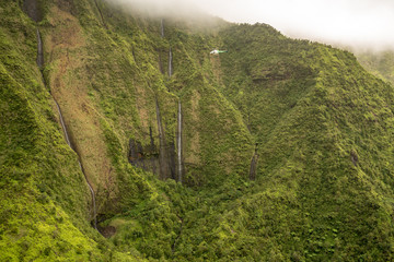 Aerial view of waterfalls in crater of Mount Waialeale on hawaiian island of Kauai from helicopter flight - Powered by Adobe