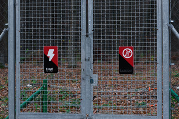 Two prohibitive signs on a metal grid