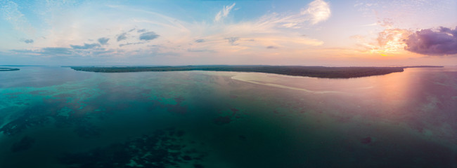 Fototapeta na wymiar Aerial view tropical beach island reef caribbean sea dramatic sky at sunset sunrise. Indonesia Moluccas archipelago, Kei Islands, Banda Sea. Top travel destination, diving snorkeling