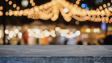 Empty black mable stone table top on abstract blurred restaurant and nightclub lights background -...