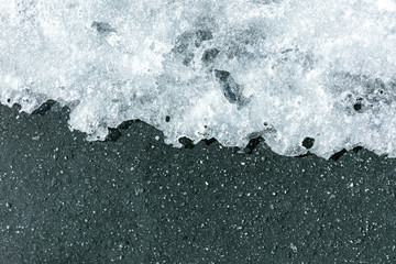 melting ice on asphalt in the spring. melting snow natural background