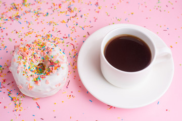 Morning coffee cup and sweet pink donut biscuits c fancy color on pink pastel table top view. Flat...