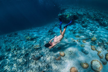 Woman free diver swim underwater in the tropical ocean