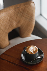 Coffee latte art on the wooden desk in coffee shop vintage color tone. Cup of coffee with beautiful...