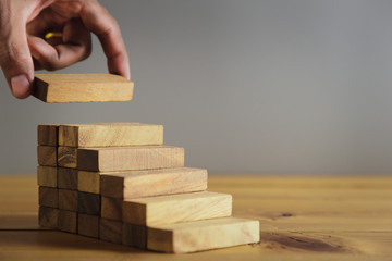 Closer up hands of businessmen,stacking wooden blocks into steps,Concept of business growth success - image