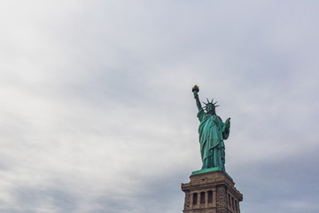Statue of Liberty against sky and clouds, in New York City, USA