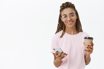 Getting energized with sip of delicious coffee. Friendly-looking african american female with cool...