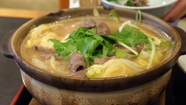 Eating Chanko nabe soup at restaurant, selective focus, shot in 4K