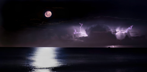 Fototapeta na wymiar moon over the sea, storm & lights