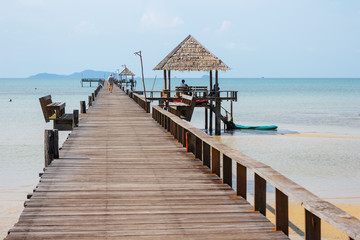 Wooden walkway bridge with seats that lead to the sea in summer in Koh Mak Island at Trat, Thailand.