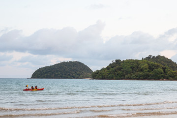 Kayak over the sea with green islands and blue, yellow sky in background in the evening in Koh Mak Island at Trat, Thailand.