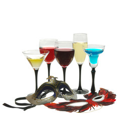Five glasses with multi-colored cocktails and masquerade masks on a light background.
