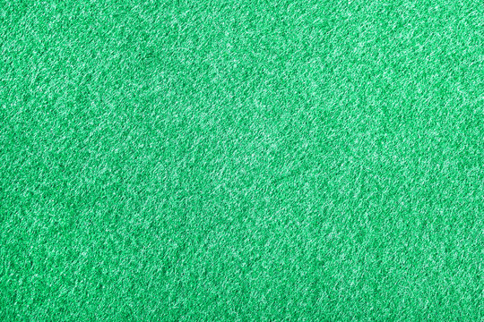 Fabric texture of green poker table closeup. Green background from a textile material closeup. Structure of the fabric with natural texture.