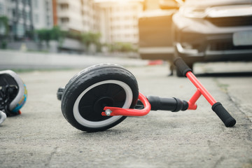 The child bike is on the ground with a car crash.