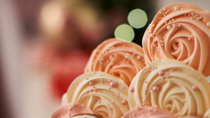 meringue pale pink in the shape of a rose or flower. meringue is a lot of cake decoration, close-up.