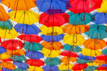 many colorful umbrellas hanging from the ceiling
