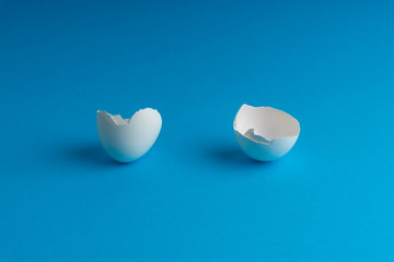 Broken eggshell on the blue background with selective focus