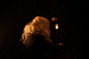 Silhouette of a woman holding lantern in the night. scary scene